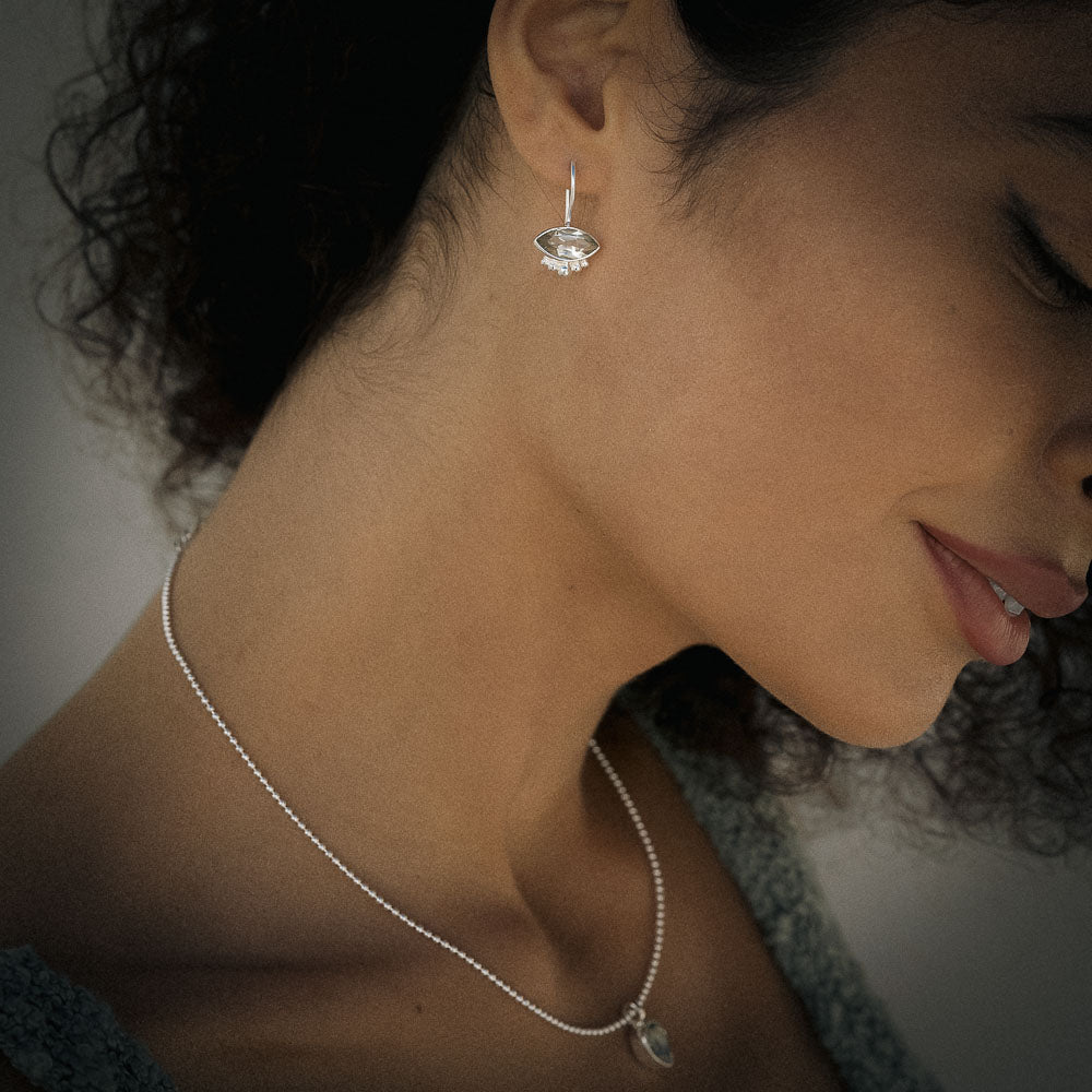 Close-up of a woman wearing a silver Green Amethyst (Prasiolite) earring and necklace.