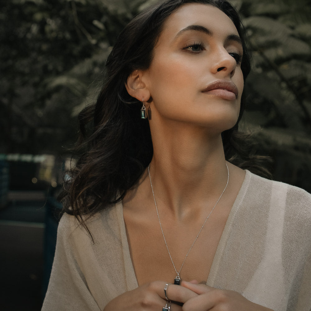 woman wearing baguette labradorite silver earrings and pendant in the jungle
