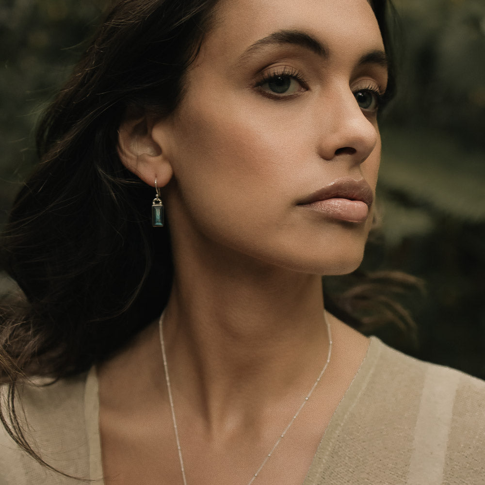 woman wearing baguette labradorite silver earrings in the jungle