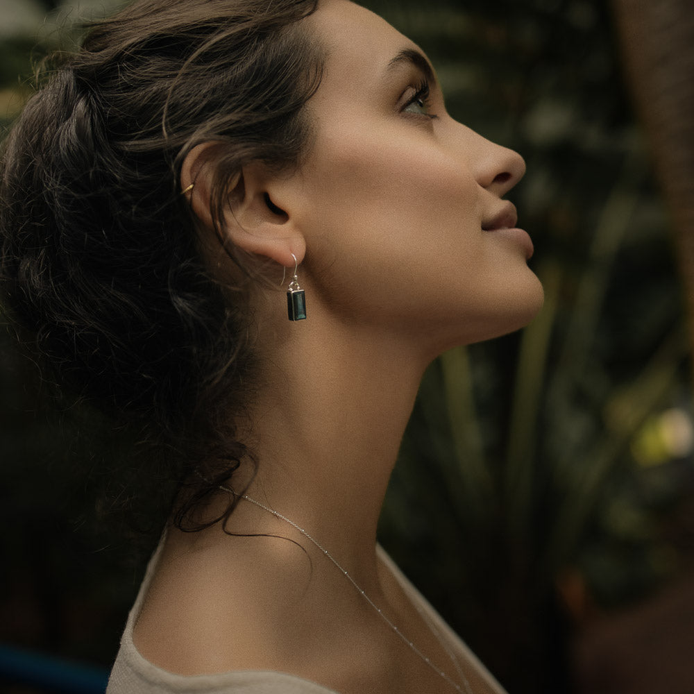 woman wearing baguette labradorite silver earrings in the jungle
