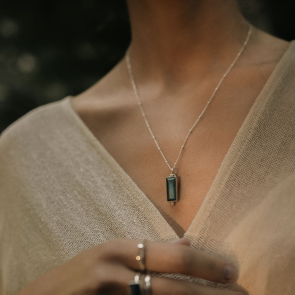 woman wearing baguette labradorite silver pendant on silver chain in the jungle