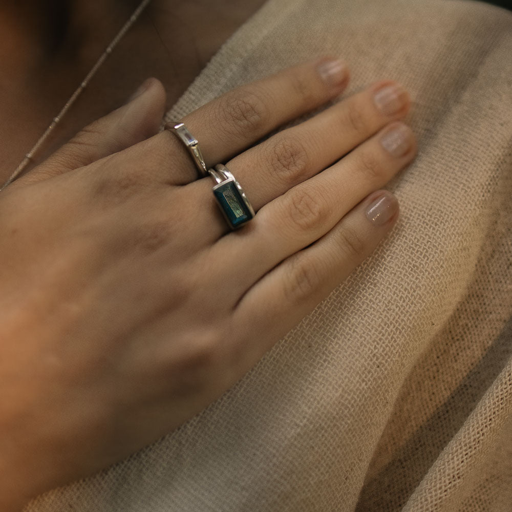 a baguette labradorite silver ring on a woman's middle finger touching