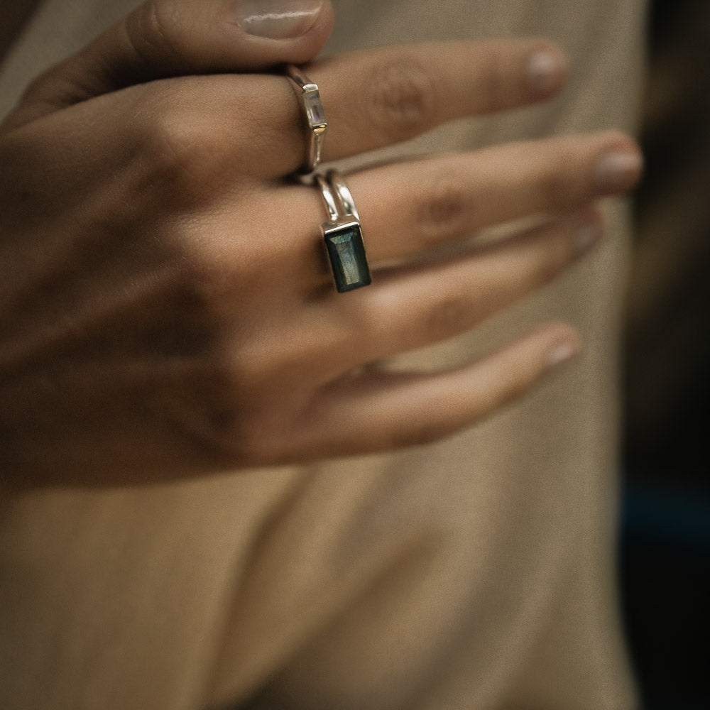 a baguette labradorite silver ring on a woman's middle finger