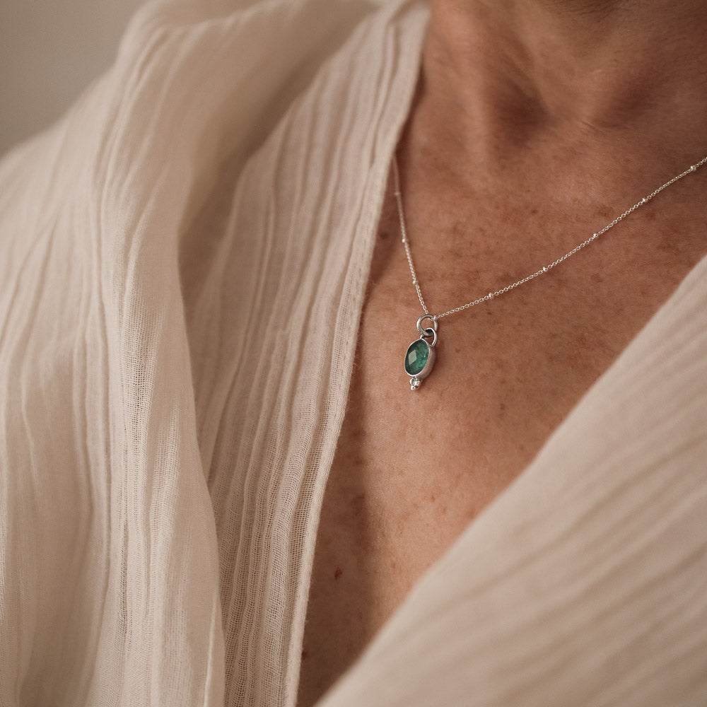 woman wearing blue tourmaline pendant on satellite chain