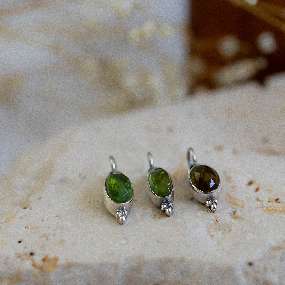 green tourmaline pendants on rustic stone