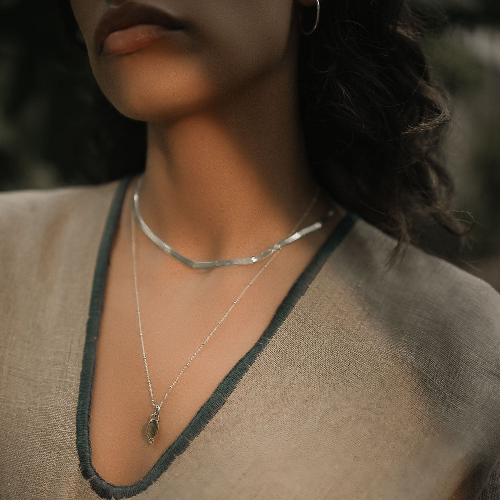 woman wearing a green tourmaline pendant on silver necklace