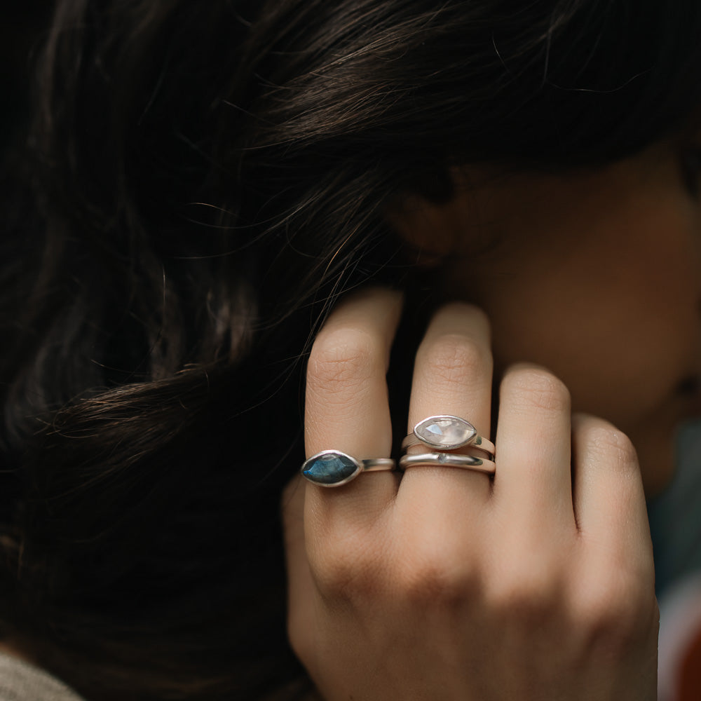 closeup of woman wearing marquise moonstone and labradorite gemstone rings
