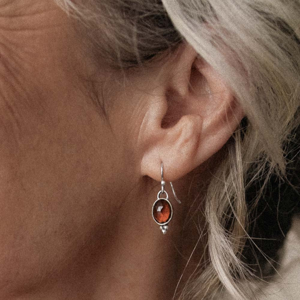 closeup of woman wearing orange tourmaline earring