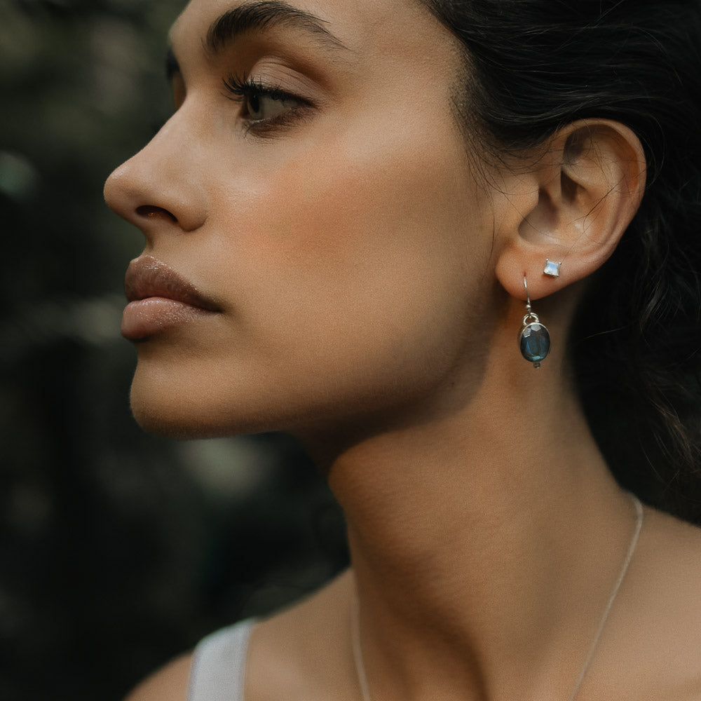 blue flashing oval labradorite earring closeup on a model