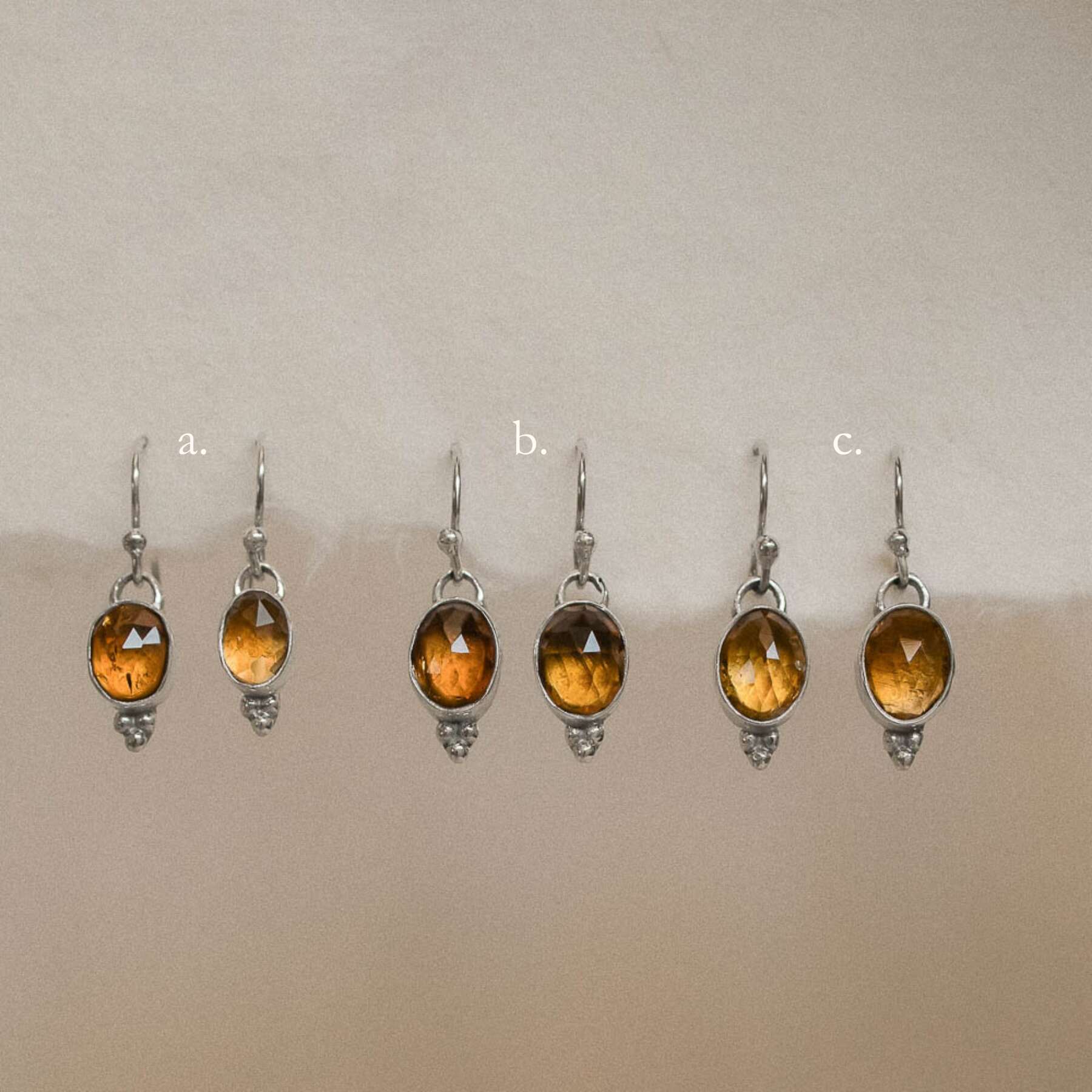pairs of orange tourmaline earrings hanging on handmade paper options