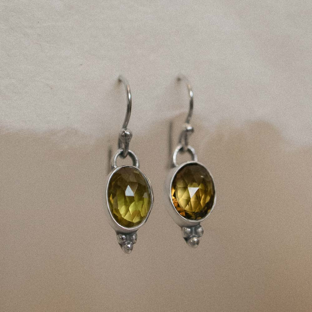 yellow tourmaline earrings hanging on handmade paper