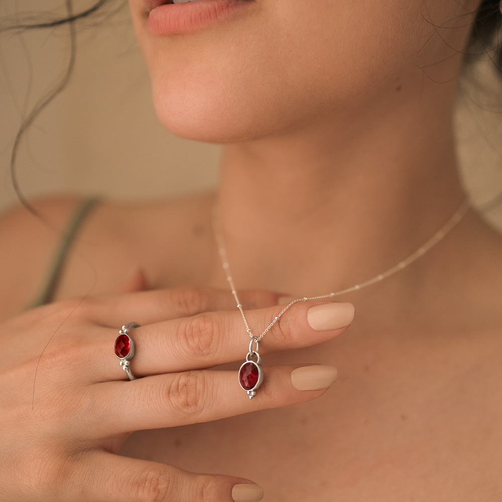 women holding a pink tourmaline pendant and ring