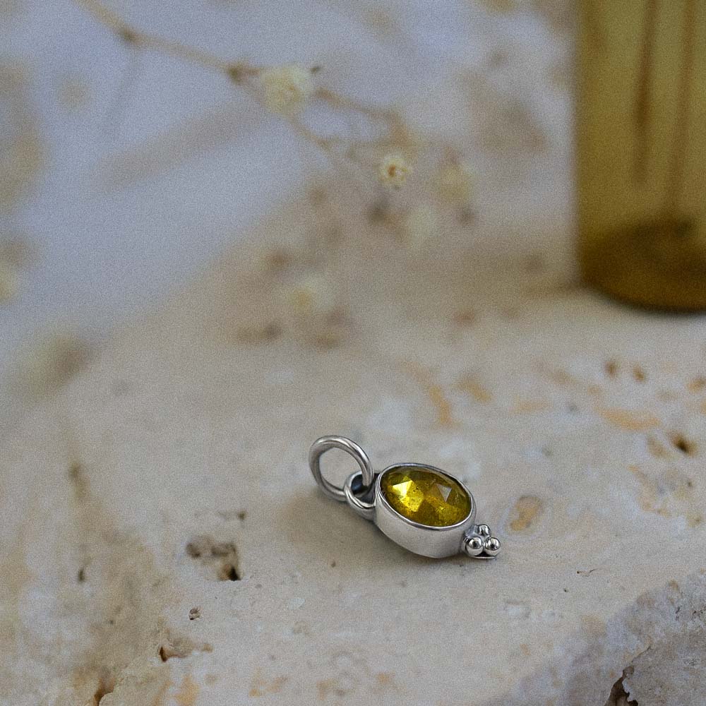 yellow tourmaline pendant on stone