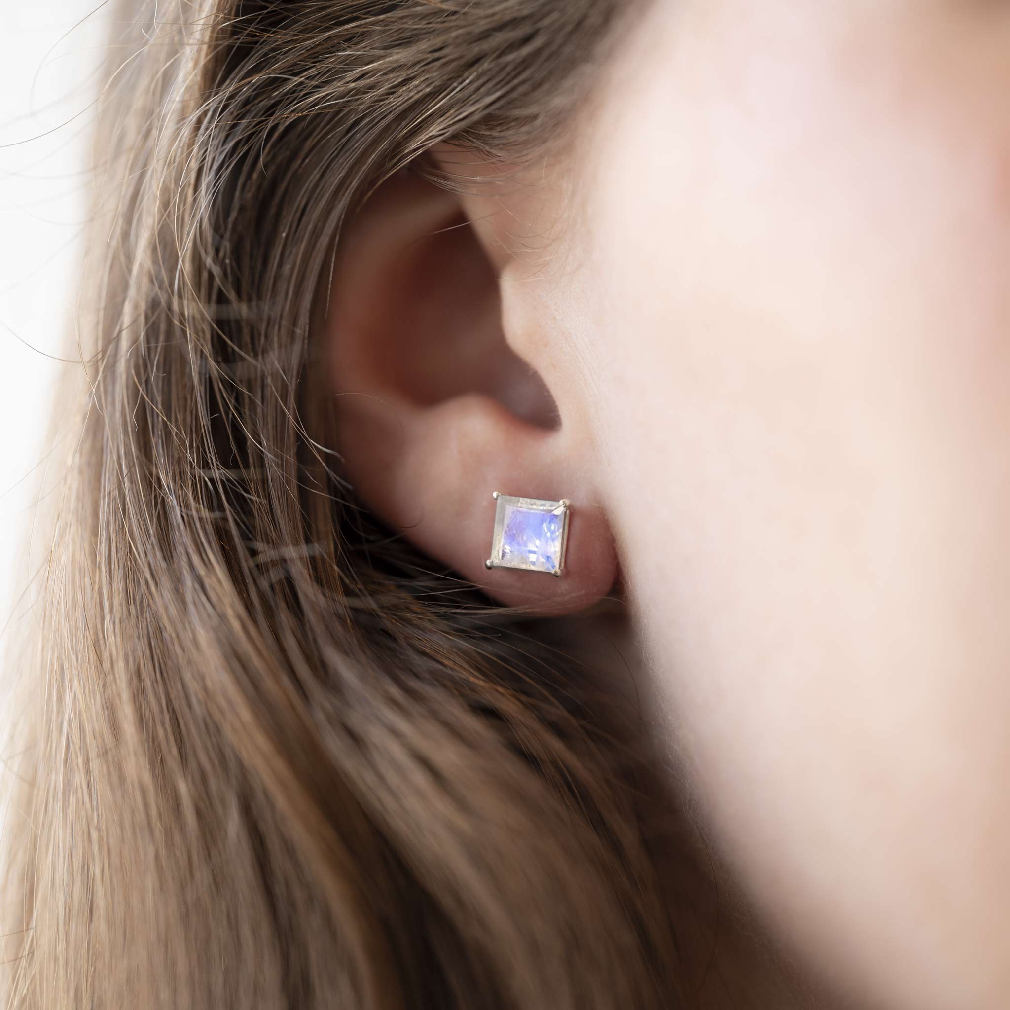 Large square rainbow moonstone silver studs flashing purple worn by model