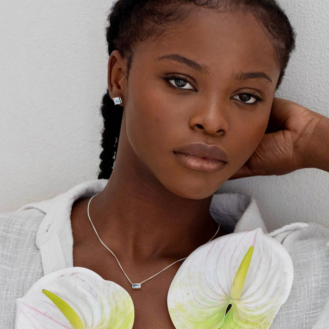 woman wearing sparkling blue silver moonstone studs in relaxed position