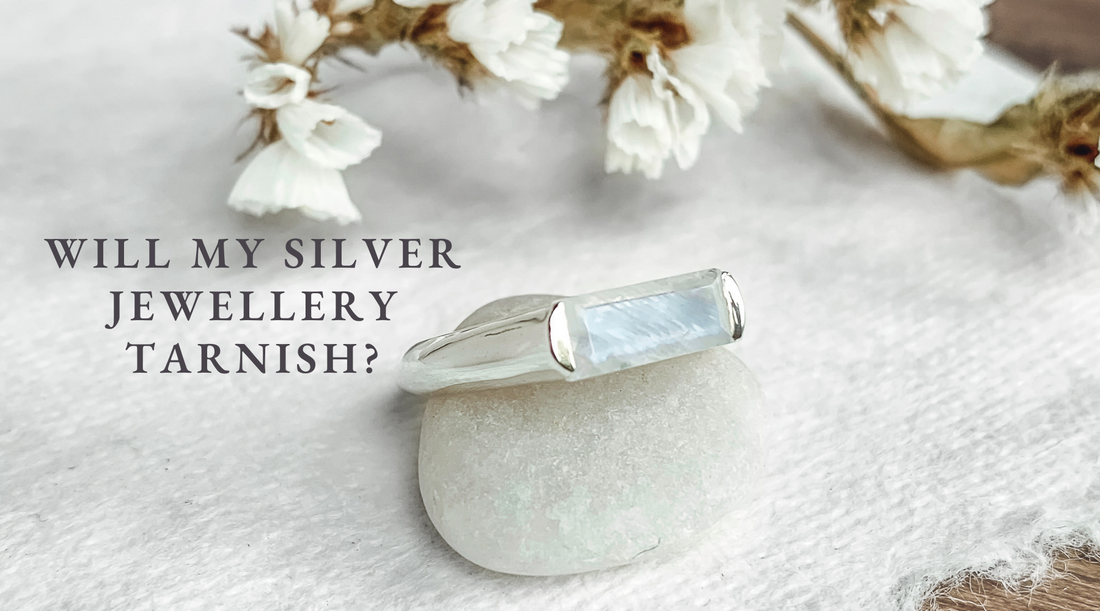 sterling silver ring featuring blue moonstone resting on a stone