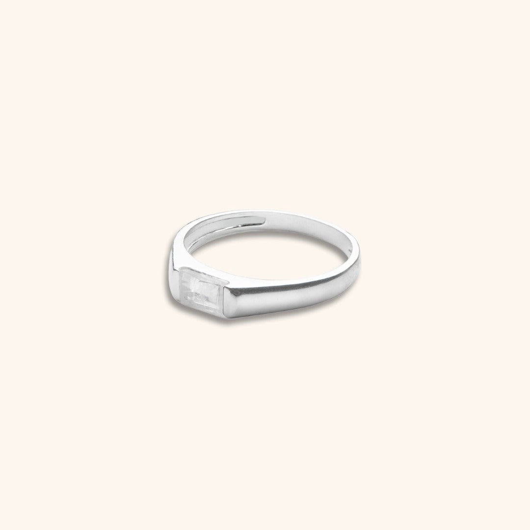 Silver ring with a rectangular stone on a white background