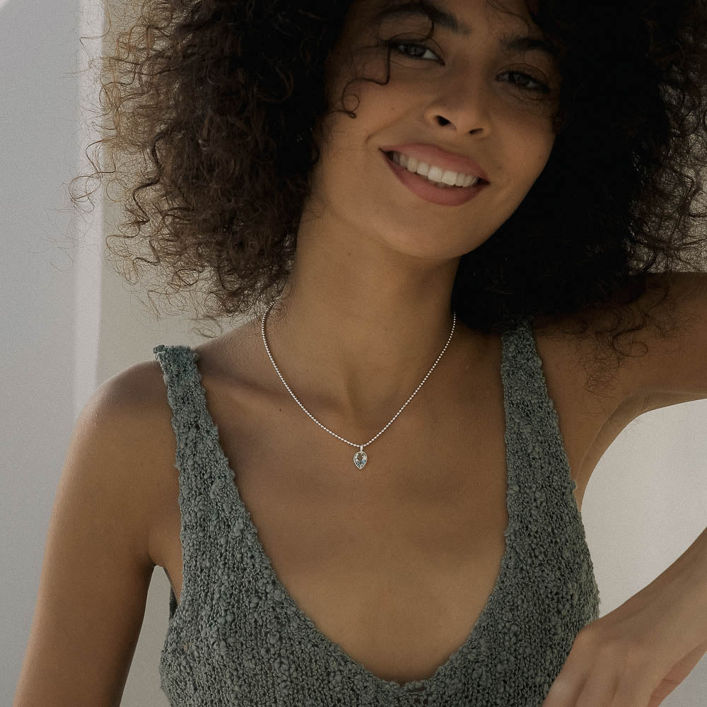 Woman wearing a gray knit top and a necklace with a pear shaped Green Amethyst (Prasiolite) pendant.