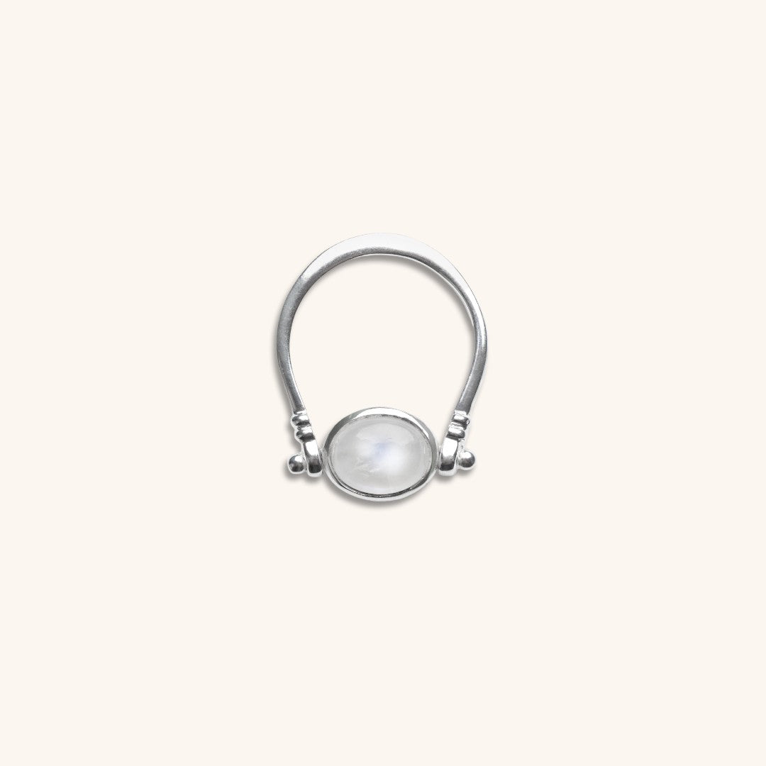 Silver ring with a round gemstone on a light gray background
