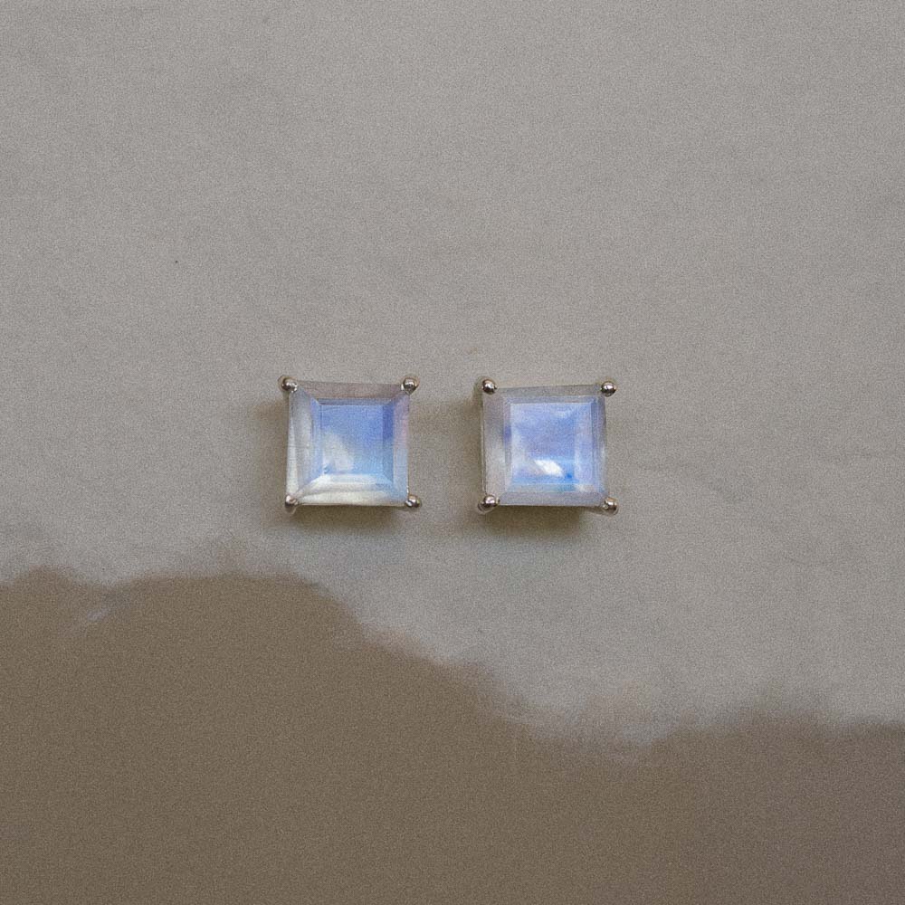 a pair of silver square moonstone earring studs in handmade paper