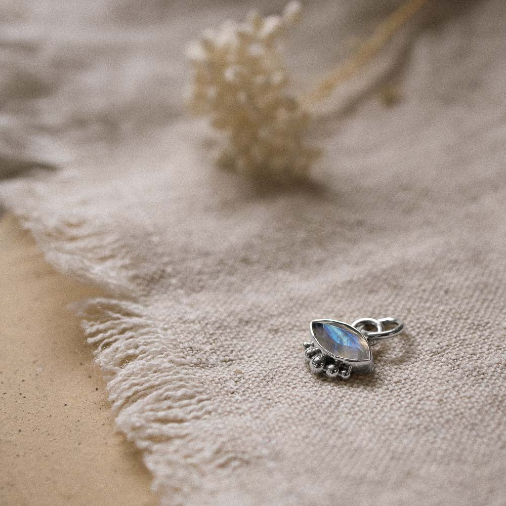 a marquise moonstone gemstone pendant resting on a linen cloth