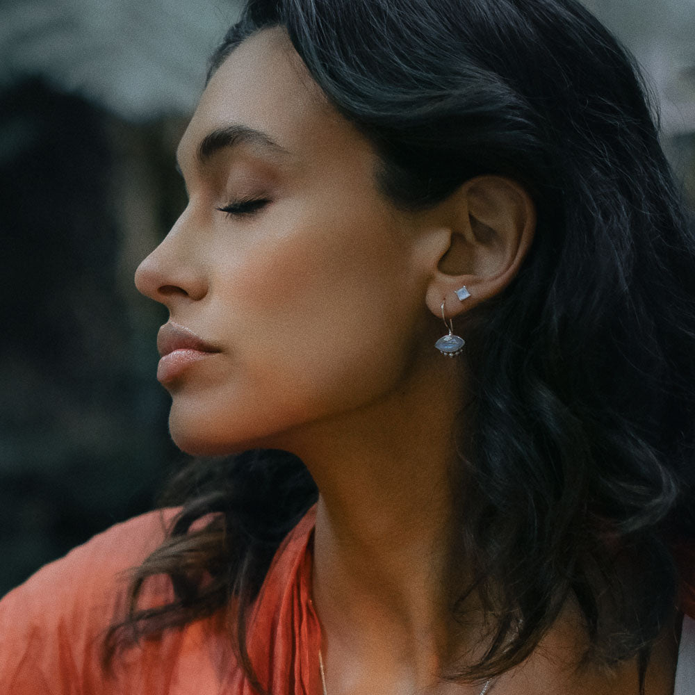 woman wearing square gemstone moonstone earring studs