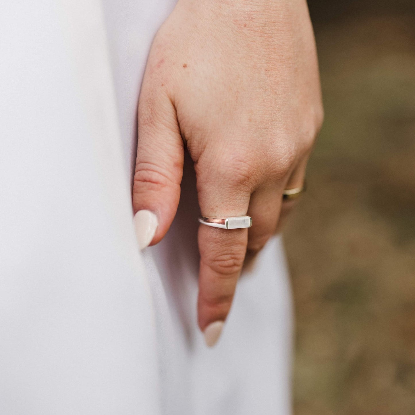 large milky baguette moonstone silver rings worn on bride's finger