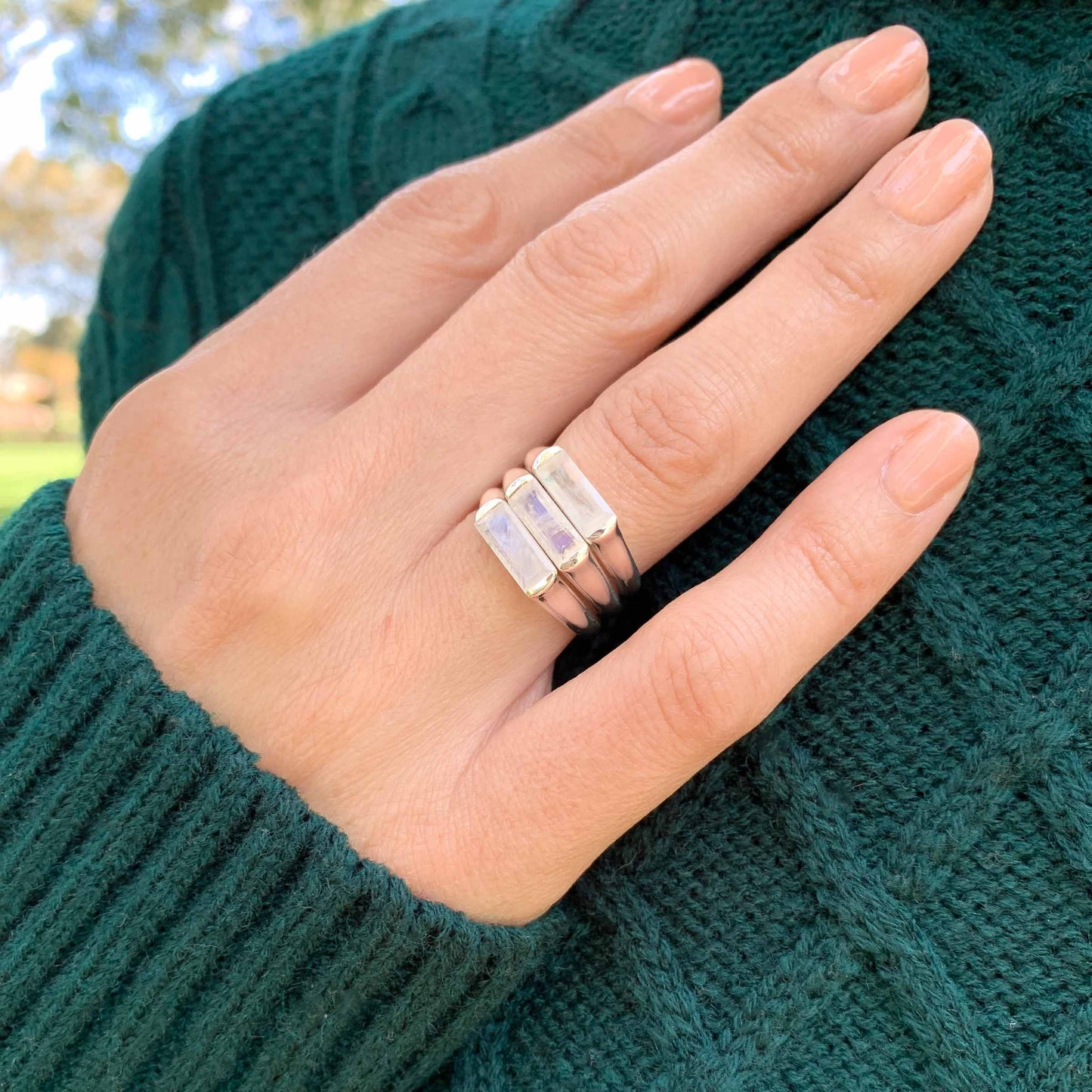 three large baguette moonstone silver ring worn on model in green jumper