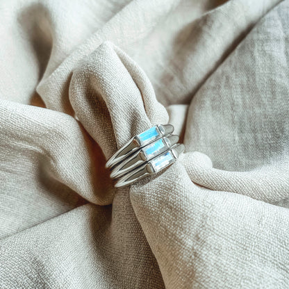 three midi baguette moonstone silver rings on linen flashing blue colours